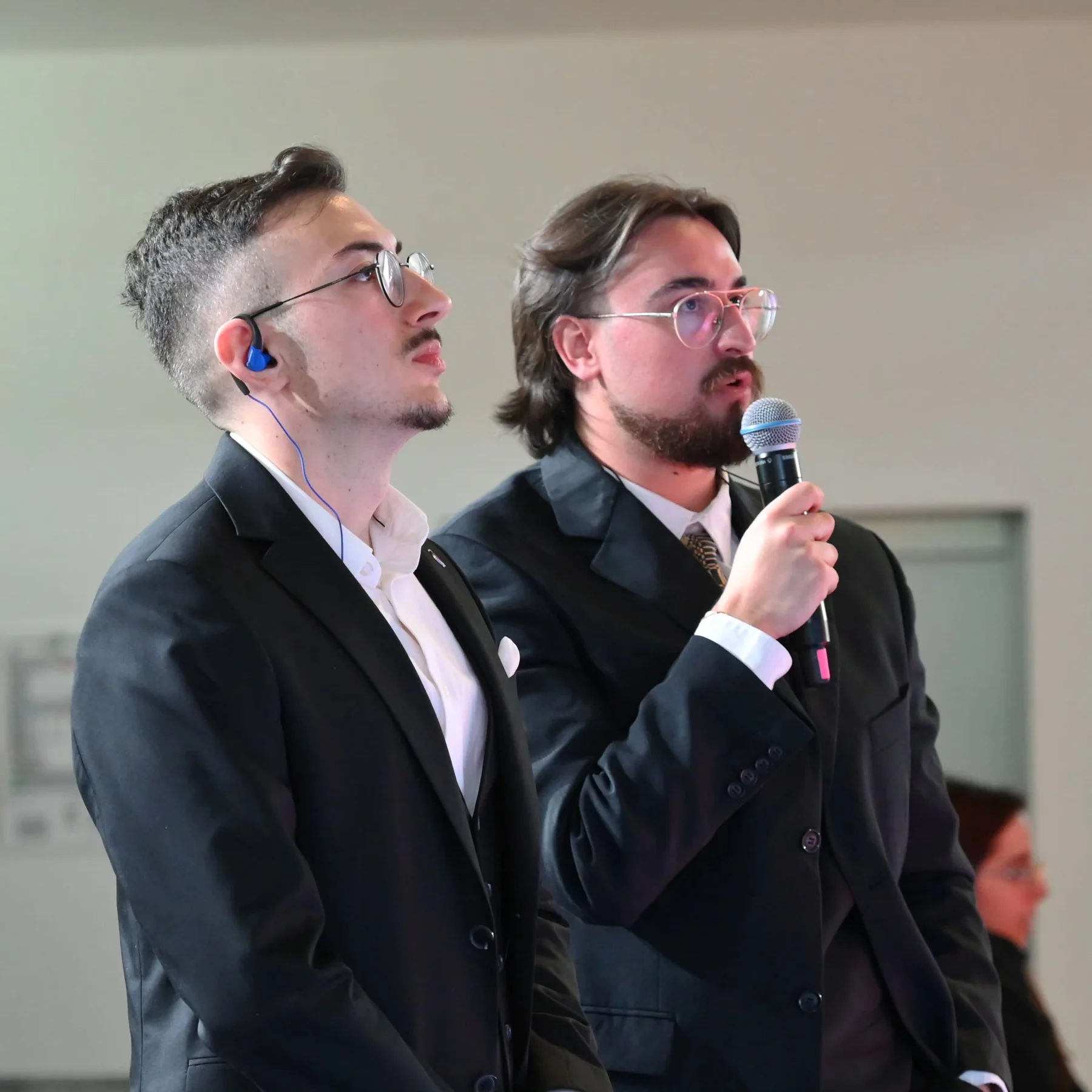 Two esports commentators following the live action, one holding a microphone
